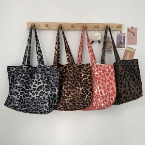 Detail showing four leopard print canvas tote bags in grey, brown, pink and green