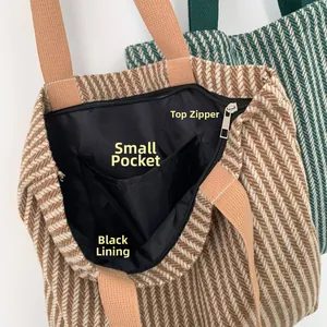 Detail view of large tote bag with zipper closure, black lining and inner pocket