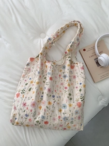 Détail de la broderie florale sur un sac cabas en toile blanc cassé style bohème