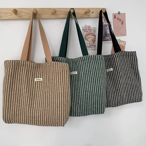 Close-up of herringbone weave textures on large capacity tote bags in three colors