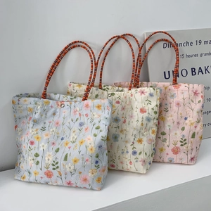 Close-up of three floral embroidery canvas tote bags with magnetic silver buckles