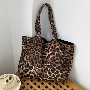 Detailed texture of leopard print canvas tote bag on a wooden seat in natural light