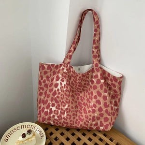 Detail of canvas tote bag showing red leopard print and magnetic metal snap closure