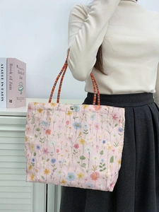 Pink canvas bucket bag featuring colorful floral embroidery and striped handles