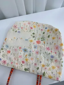 Macro view of floral embroidery on canvas tote with colorful braided strap and button