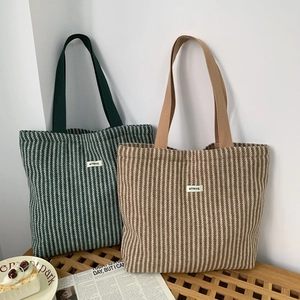 Close-up of herringbone woven texture and square label on large capacity tote bags