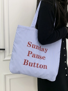Détail de l'imprimé rouge Sunday Pause Button sur le sac cabas en toile à rayures