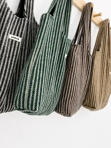 Detailed view of knitted tote bags featuring herringbone patterns in four assorted colors