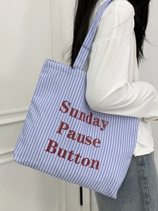 Détail du cabas en toile rayé bleu et blanc avec texte rouge Sunday Pause Button