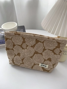 Close-up of khaki rose embossed jacquard cosmetic bag with vintage fabric texture