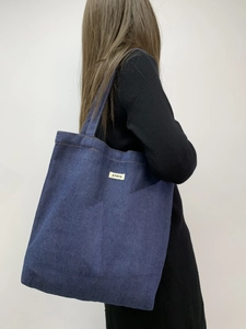 Detail of dark blue denim tote bag with ATRYG logo patch and durable twill texture