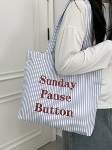 Détail du sac cabas en toile rayé bleu avec lettrage rouge Sunday Pause Button