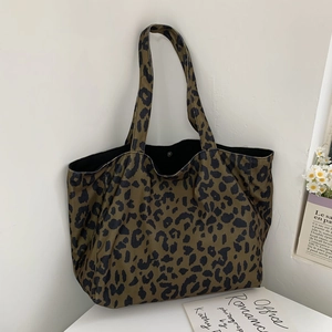 Detail of leopard print corduroy tote bag featuring snap closure and spacious interior