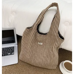 Detailed herringbone wool tote bag with ATRYG label shown near laptop and coffee cup