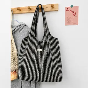 Detail of herringbone pattern tote bag with ATRYG label and durable canvas texture