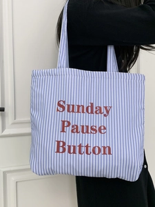 Détail du sac cabas en toile à rayures bleues avec imprimé Sunday Pause Button
