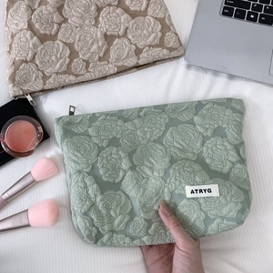 Detail of rose embossed jacquard fabric and metal zipper on this stylish makeup bag