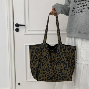 Detail of leopard print tote bag with magnetic snap closure and canvas shoulder straps