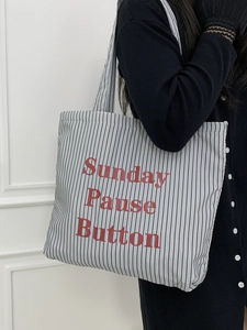 Détail du grand sac cabas en toile rayée grise avec texte Sunday Pause Button rouge