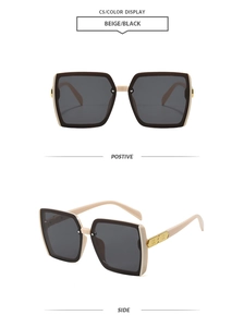 Detail of square oversized sunglasses in beige and black with golden metal temple accents