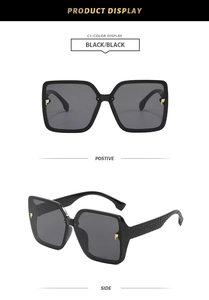 Detail of square black sunglasses showing gold P hardware and textured temples