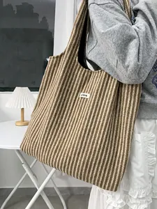Close-up of a brown and white striped wool tote bag showing texture and logo detail