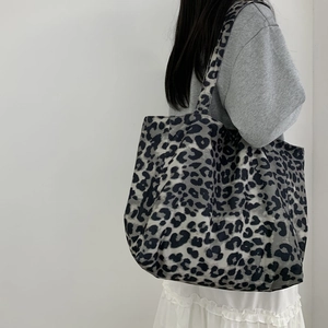 Close-up of leopard print canvas tote bag showing the wide strap and texture details