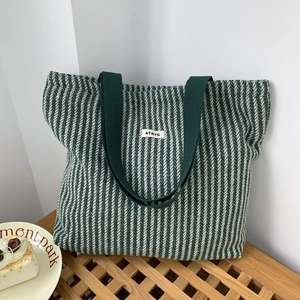 Detail of green and white striped wool tote bag with large capacity and fabric handle