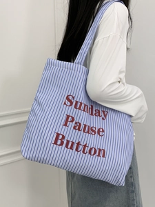 Détail du sac cabas en toile à rayures bleues et blanches avec imprimé Sunday Pause