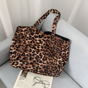 Close-up of leopard print canvas tote bag with glasses and newspaper background