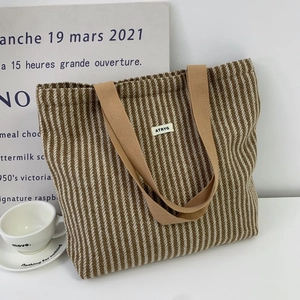 Detail of wool tote bag featuring brown herringbone pattern and ATRYG brand label