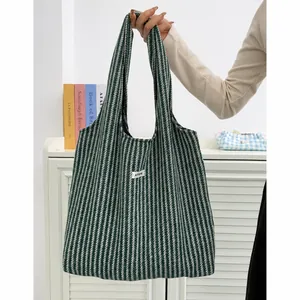 Detailed close-up of large wool tote bag with green herringbone pattern and ATYRG label