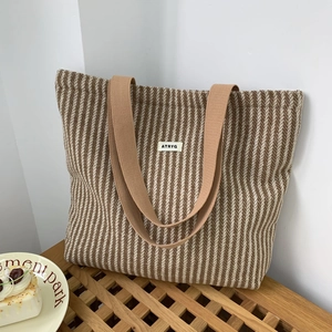 Close-up of herringbone knit texture and brand label on large capacity tote bag