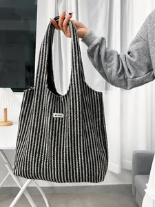 Macro view of black and white herringbone wool tote bag featuring an ATRYG woven label