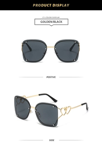 Detail of rimless square sunglasses with gold heart-shaped temple accents and metal rivets