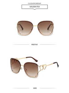 Detail of rimless square sunglasses featuring golden double-heart cutout temples and tea lenses