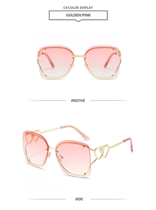 Detail view of pink gradient rimless sunglasses with gold heart-shaped temple design