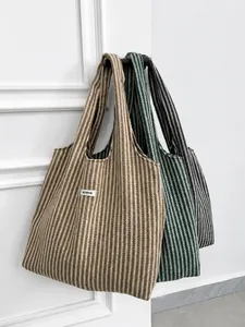 Detailed view of herringbone knit tote bags in brown, green, and grey colors