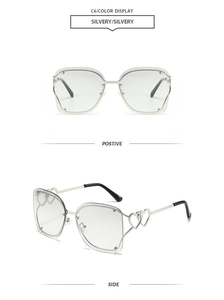 Detail of silver rimless square sunglasses with hollow heart hinges and metal rivets