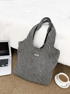 Close-up of a black and white herringbone wool tote bag with ATRYG brand label