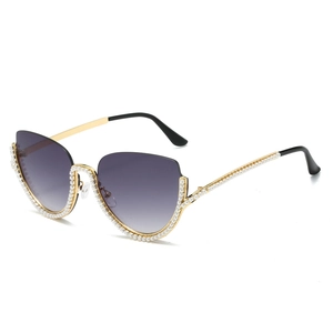 Lunettes de soleil œil de chat monture métallique avec perles sur fond blanc pur