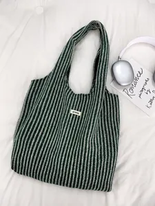 Detail of green herringbone knit tote bag with ATRYG label and soft textured finish