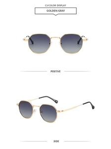 Close-up of golden octagonal metal sunglasses with gray gradient lenses and slim frame