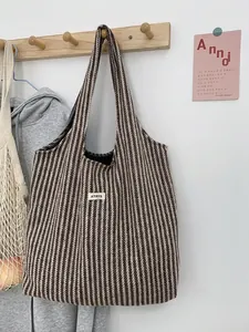 Detail of wool-like stripe tote bag with ATRYG label on home wall hanger