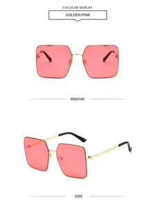 Close-up of golden square frame sunglasses with pink lenses and slim metal temples