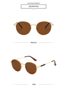 Detail view of oval retro sunglasses with golden metal frames and brown lenses