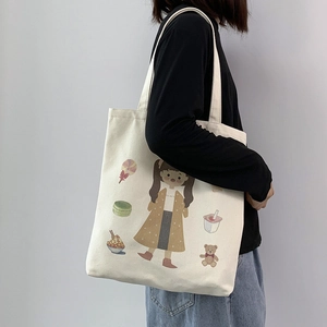 Close-up of off-white canvas tote bag featuring cute cartoon girl and dessert prints