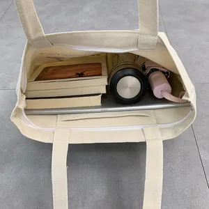 Interior view of beige canvas tote bag showing large capacity for books and tablet