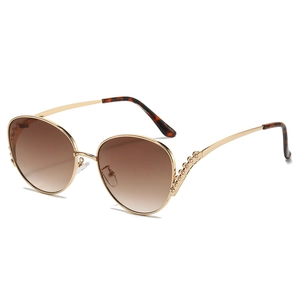 Women's oversized gold metal sunglasses with diamond accents and brown gradient lenses