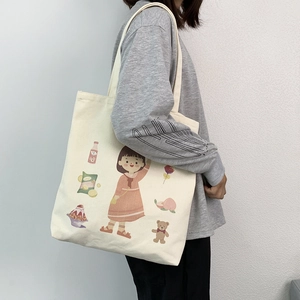 Detail of canvas tote bag with cute cartoon girl illustration and sturdy shoulder strap